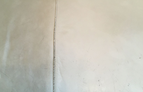 "Expert upholstery cleaning service by Dirt Busters, revitalizing a sofa with advanced cleaning tools."