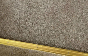  "Professional carpet cleaning in progress by Dirt Busters, showcasing deep-cleaning equipment on a stained carpet."